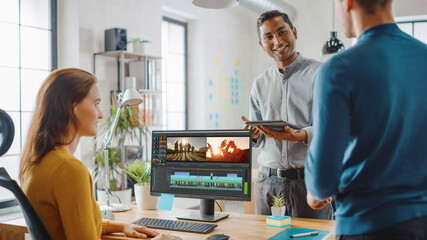 Wall Mural - handsome male art director consults beautiful woman videographer. three beautiful video editors coll