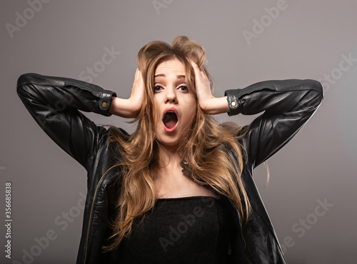 Fotografía Natural fair blond hair female with natural surprising emotions crying with wide opened mouth and holding head