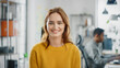 Leinwandbild Motiv Portrait of Beautiful Young Woman with Red Hair Wearing Yellow Sweater Smiling at Camera Charmingly. Successful Woman Working in Bright Diverse Office.