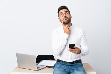 Wall Mural - Young businessman holding a mobile phone thinking an idea