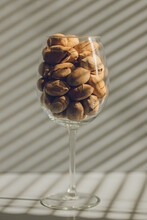 Wine Glass Filled With Pecans On A Gray Background.