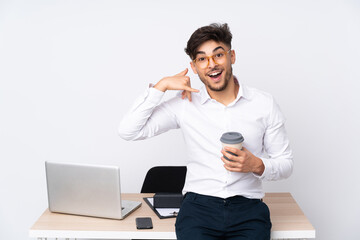 Arabian man in a office isolated on white background making phone gesture. Call me back sign