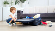 © Kyrylo Ryzhov - Cute toddler boy looking in suitcase packed for holiday vacation on beach