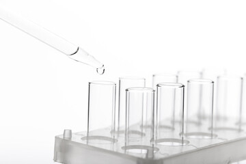 pipette with a drop and scientific laboratory test tubes in a research laboratory.