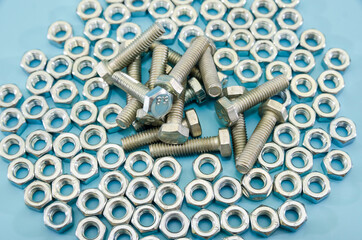 pile of bolts and nuts on a blue background. Background with nuts and bolts.