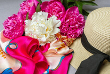 Mix Peony Bouquet, Woman’s Straw Hat And Silk Scarf On Lilac Background. Close Up.