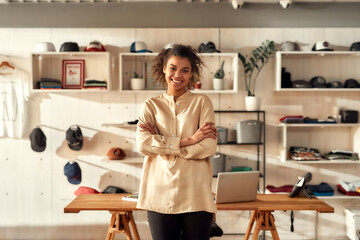 Poster - Happy to be here. Portrait of young smiling female worker looking at camera while standing in the office. Woman working at custom T-shirt, clothing printing company