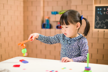 Wall Mural - toddler girl play magical magnet experiments at home for homeschooling