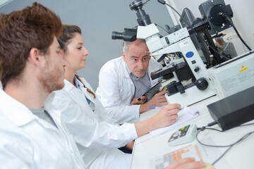  Group of students with microscope in laboratory