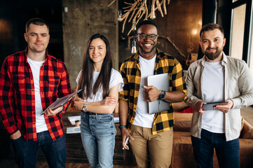 Portrait of successful business team. Creative modern office. Group of ambitious professionals dressed in stylish casual wear are standing in their modern office space