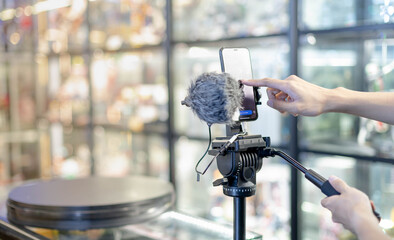 male hand is shooting a video using gimbal and smart phone on tripod for live about the product for 