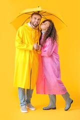 Poster - Happy young couple with umbrella on color background