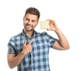 Wall Mural - Handsome young man with tasty chocolate on white background