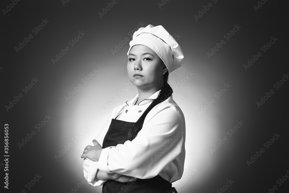 Toned portrait with beautiful Asian chef on dark background