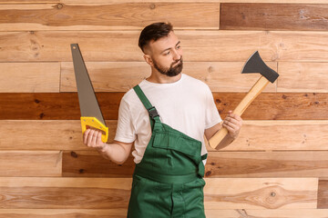 Canvas Print - Handsome lumberjack with axe and saw on wooden background