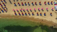 Aerial Top View Of Tourists With Umbrellas At Beach On Sunny Day, Drone Ascending Over People On Shore - Tel Aviv, Israel