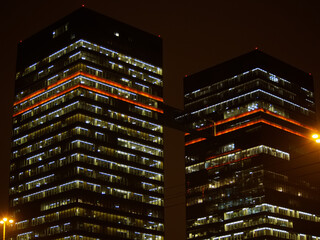 Two high-rise buildings connected by a transition in the night city