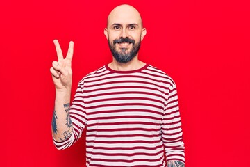 Poster - Young handsome man wearing casual clothes smiling with happy face winking at the camera doing victory sign. number two.