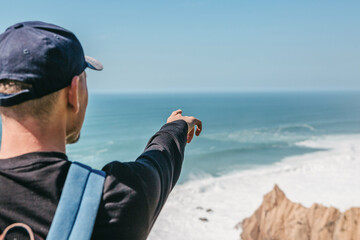 Wall Mural - Tourist shows a hand to the sea