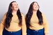 Young plus size twins wearing casual clothes looking away to side with smile on face, natural expression. laughing confident.