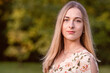 © ako-photography - Portrait of a young blonde woman against a defocused landscape. Autumn color shade.