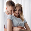 © LIGHTFIELD STUDIOS - handsome man hugging beautiful and smiling girl with closed eyes