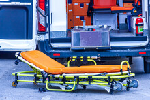 A Stretcher Stands In Front Of The Ambulance 