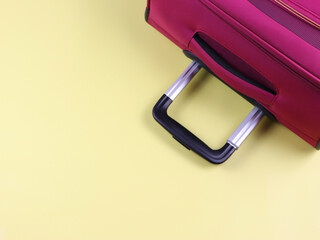 Travel concept , Top view of pink luggage handle on  yellow background