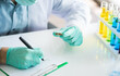 © Supagrit Ninkaesorn - Professional Asian scientist or researcher man in work coat uniform examine liquid sample and record result detail in science lab