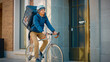 © Gorodenkoff - Handsome Happy Food Delivery Man Wearing Thermal Backpack Rides his Bike Through the Stylish Modern City District. Shot of Smiling Courier Delivering Restaurant Order Safely.