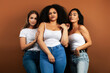 © iordani - young pretty asian, caucasian, afro woman posing cheerful together on brown background, lifestyle diverse nationality people concept