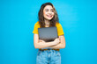 © F8  \ Suport Ukraine - Young beautiful girl is holding a laptop in her hands on a blue background.