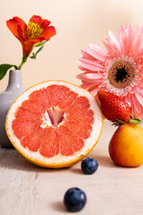 Poster - floral and fruit composition with Alstroemeria, gerbera, berries, grapefruit and apricot on wooden surface isolated on beige