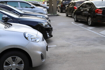 Closeup of front side of bronze car with  other cars parking in outdoor parking area,