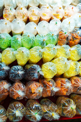 Wall Mural - Colored desserts in plastic bags at a street food market in Asia. Unusual Asian food.