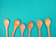 Wooden spoons set on bright turquoise background. Culinary, cooking concept. Top view, copy space, flat lay.