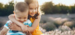 © Strelciuc - Caucasian brother and sister posing and embracing in a lavender field while looking at camera and smile