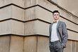 © KIFOR PRODUCTION - A young guy, a businessman in a suit with a tie, looks, stands on a cool background. Place for text. Success is near. The path to progress.