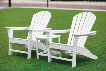 white lawn chairs on green grass