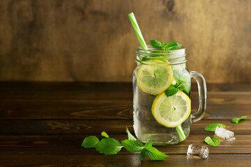 Fresh natural drink with lemon and mint in a glass mug. Fruit water. Detox.