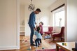 © Maskot - Playful children talking to father while standing at home