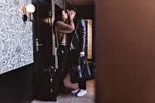 Side View Of Couple Kissing At Entrance Of Hotel Room