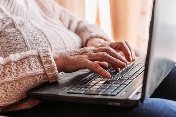 Elderly woman hands typing on the keyboard. Quarantine life