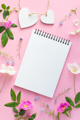 Wall Mural - Mockup Flowers on pink background with notebook