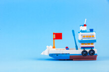 A Fishing Boat Toy Isolated On A Blue Background.