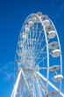 A white ferris wheel with a blue sky