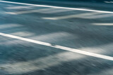 Fototapeta Tęcza - Hintergrundmotiv: Licht und Schatten auf einer leeren Straße in Bewegungsunschärfe