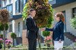 © zinkevych - Tall man in a black suit shaking hands with a female partner