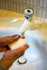 Canvas Print - Person thoroughly washing hands rubbing with soap in the sink for coronavirus protection