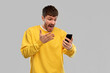 © Syda Productions - technology, communication and people concept - angry young man with smartphone over grey background